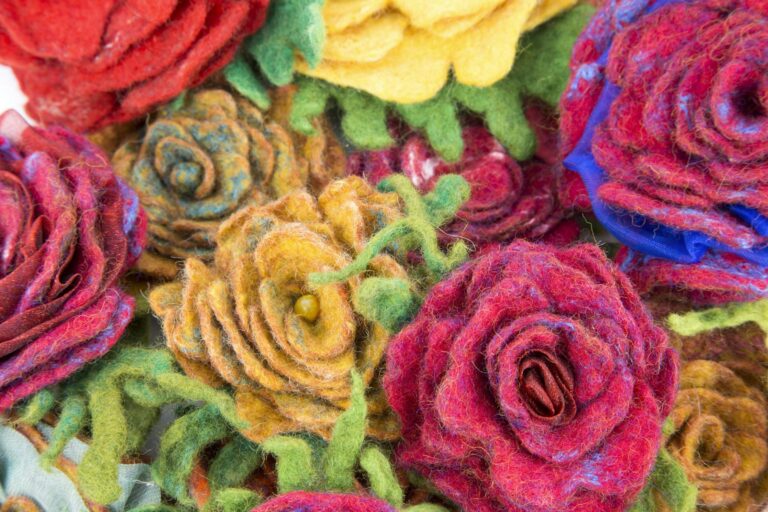 A close-up of vibrant handmade felt roses with rich textures and colors.